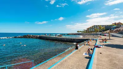 a group of people swimming in the water at a beach at Apartamento Bartolomeu By Horizon View Madeira in Caniço