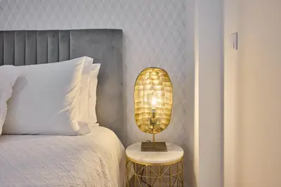 a lamp on a side table next to a bed at Panoramic Pearl by Homie in Funchal