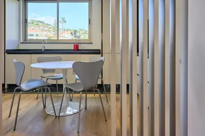 a table and chairs in a kitchen with a window at Panoramic Pearl by Homie in Funchal