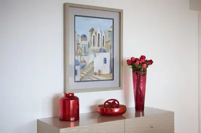a vase with roses in it on a shelf with a painting at Panoramic Pearl by Homie in Funchal