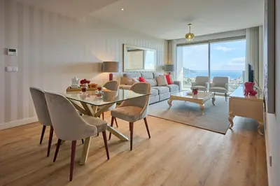 a living room with a dining table and a couch at Panoramic Pearl by Homie in Funchal