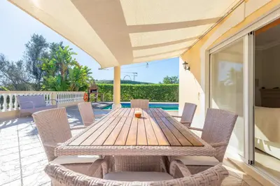 a patio with a wooden table and chairs at Lote 50 at Boavista Resort Lagos in Lagos