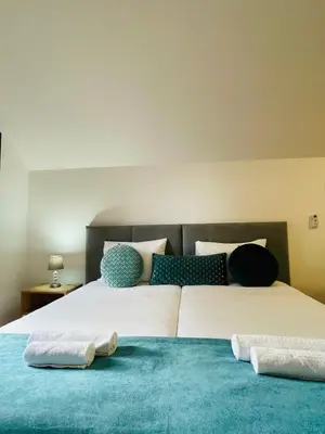 two beds with towels sitting on top of them at Cozy House in Funchal