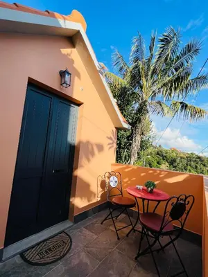 a patio with a table and chairs on a house at Cozy House in Funchal