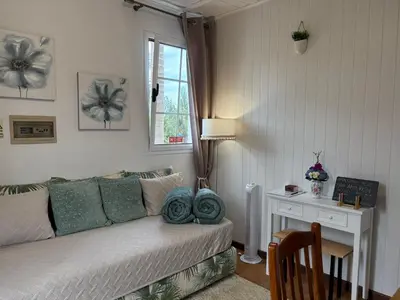 a living room with a table and a tv on a wall at Villa Alta Vista in São Jorge