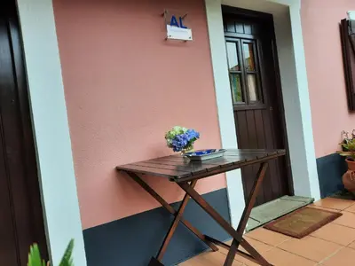 a table in front of a house with a vase of flowers on it at Casa Rosa in Camacha