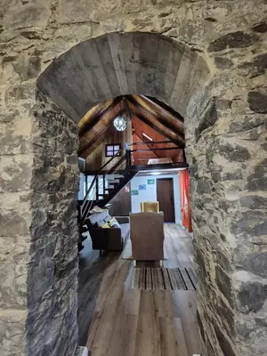 a living room with a stone wall and a chair at Casa Rosa in Camacha