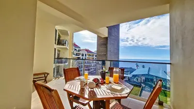a dining room with a table and a large window at Sunset Bay by LovelyStay in Funchal