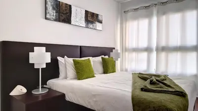 a bedroom with a large bed with green pillows at Sunset Bay by LovelyStay in Funchal