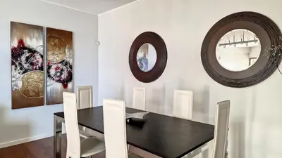 a dining room with a black table and two mirrors at Sunset Bay by LovelyStay in Funchal