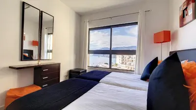 a bedroom with a bed and a large window at Sunset Bay by LovelyStay in Funchal