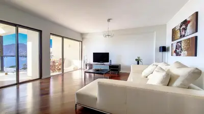 a living room with a white couch and a television at Sunset Bay by LovelyStay in Funchal
