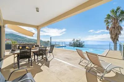 a bed with white sheets and two lights on it at 17 ° West, Lux. Inf. Pool villa, 5 minutes to the sandy beach, WiFi in Estreito da Calheta