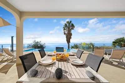 a large bed with white sheets and pillows at 17 ° West, Lux. Inf. Pool villa, 5 minutes to the sandy beach, WiFi in Estreito da Calheta