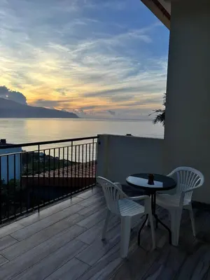 a balcony with a table and chairs and a view of the ocean at The Vista House in Ponta Delgada