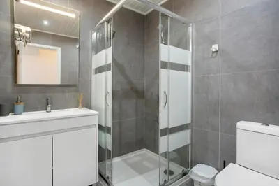 a white bathroom with a sink and a bed at Refúgio Na Cidade 104 in Funchal