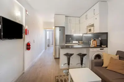 a living room with a couch and a kitchen at Refúgio Na Cidade 104 in Funchal