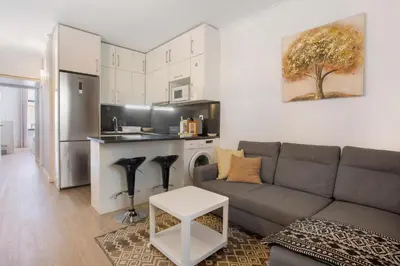 a kitchen with white cabinets and black counter tops at Refúgio Na Cidade 104 in Funchal