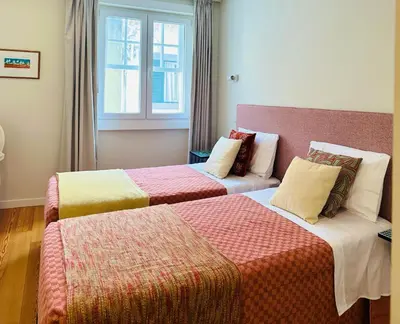 two beds in a hotel room with a window at ISABELLA STUDIOS FUNCHAL in Funchal