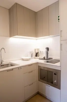 a small kitchen with white cabinets and a sink at ISABELLA STUDIOS FUNCHAL in Funchal