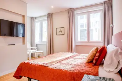 a bedroom with a bed and a tv and windows at ISABELLA STUDIOS FUNCHAL in Funchal