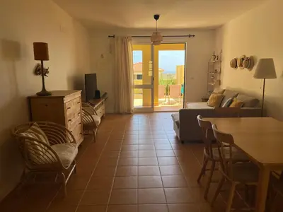 a living room with a couch and a table and chairs at Porto Santo Happy Place in Porto Santo