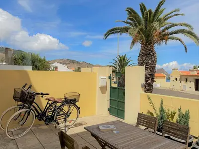 a bike parked next to a yellow wall with a palm tree at Porto Santo Happy Place in Porto Santo