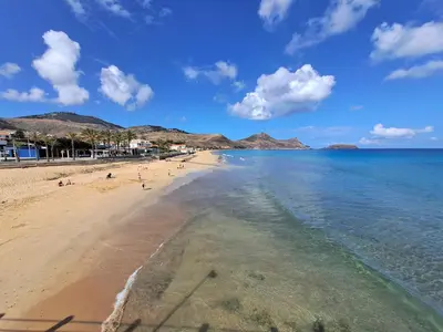 a beach with people on the sand and the water at Porto Santo Happy Place in Porto Santo