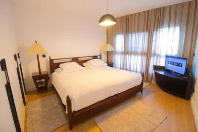 a bedroom with a bed and a flat screen tv at Apartamento Zona Turística in Funchal