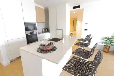a white kitchen with a sink and a counter at Apartamento Zona Turística in Funchal