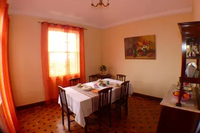 a dining room with a table with chairs and a window at Casa da Avó Benvinda in Funchal