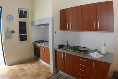 a kitchen with wooden cabinets and a counter top at Casa da Avó Benvinda in Funchal