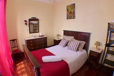 a bedroom with a bed and a dresser and a mirror at Casa da Avó Benvinda in Funchal