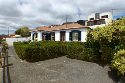 a white house with a hedge in front of it at Casa da Avó Benvinda in Funchal