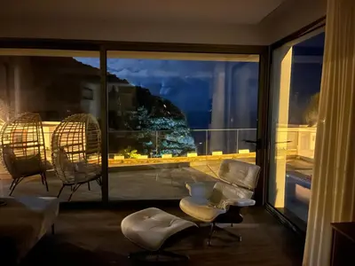 a fire on the side of a mountain near the ocean at One Sweet World in Calheta