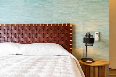 a bedroom with a bed and a wooden headboard at One Sweet World in Calheta