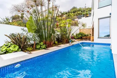 a swimming pool with a water feature in a house at One Sweet World in Calheta