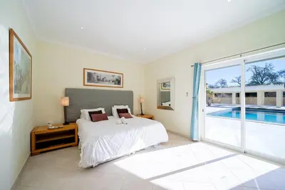 a bedroom with a bed and a swimming pool at Casa Ferrel - Luxury 9 Bedroom Villa with Indoor & Outdoor Pools in Lagos