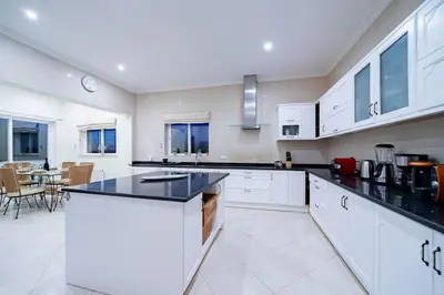 a kitchen with white cabinets and black counter tops at Casa Ferrel - Luxury 9 Bedroom Villa with Indoor & Outdoor Pools in Lagos