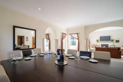 a large dining room with a large table with wine glasses at Casa Ferrel - Luxury 9 Bedroom Villa with Indoor & Outdoor Pools in Lagos