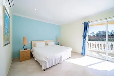 a white bedroom with a bed and a window at Casa Ferrel - Luxury 9 Bedroom Villa with Indoor & Outdoor Pools in Lagos