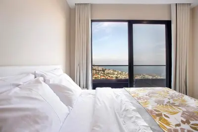 a bedroom with a white bed with a large window at Dream View in Funchal