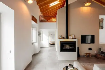 a living room with a fireplace and a tv at Casa elegante em Vila tranquila in Barão de São Miguel