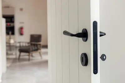 a door with a black handle in a room at Casa elegante em Vila tranquila in Barão de São Miguel