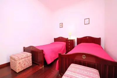 two beds in a room with pink sheets at Costa's OldTown House in Funchal in Funchal