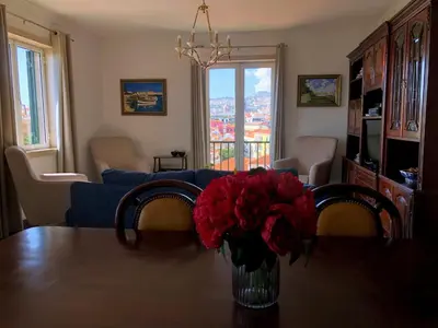 a living room with a table with a vase of red flowers at Costa's OldTown House in Funchal in Funchal