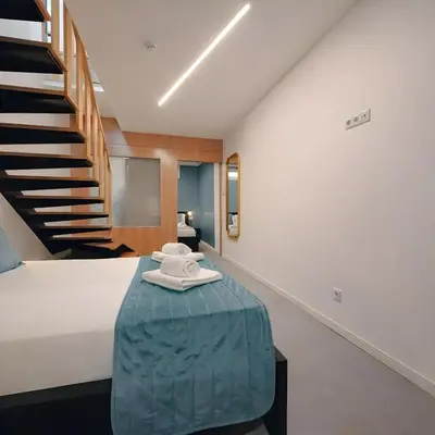 a living room with a blue couch and a table at Social Lodge Piornais Duplex in Funchal