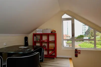 a dining room with a red table and a window at Quinta dos Cardais by AnaLodges in São Vicente