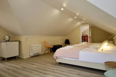 a bedroom with a bed and a table and chairs at Quinta dos Cardais by AnaLodges in São Vicente