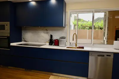 a kitchen with blue cabinets and a sink and a window at Quinta dos Cardais by AnaLodges in São Vicente